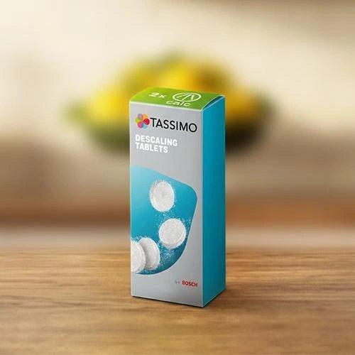Box of descaling tablets for coffee machine on wooden surface with blurred background